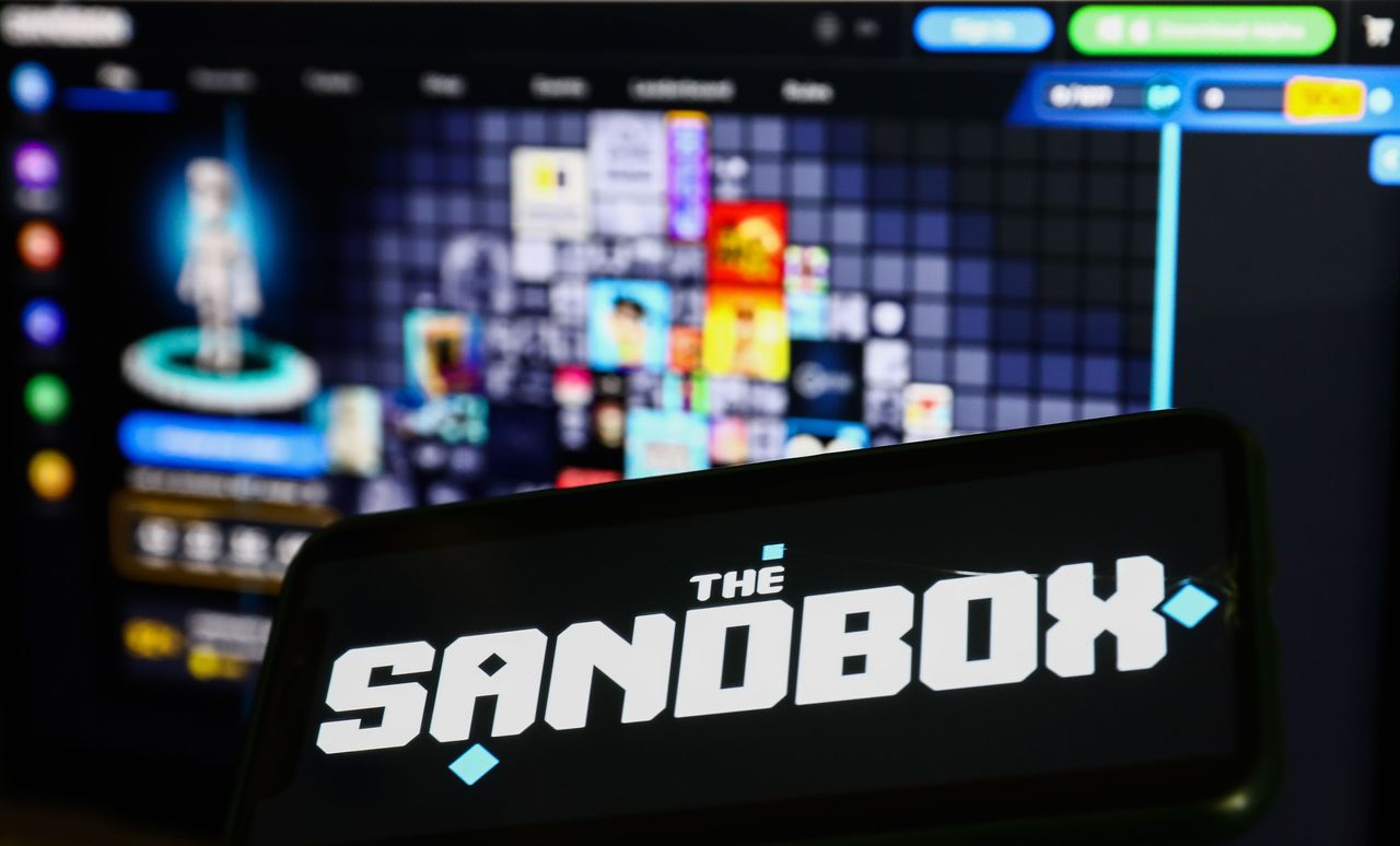 The Sandbox logo displayed on a phone screen and The Sandbox website displayed on a laptop screen are seen in this illustration photo taken in Krakow, Poland on September 18, 2022. (Photo by Jakub Porzycki/NurPhoto via Getty Images)