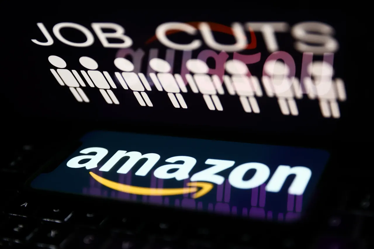'Job cuts' sign and stick figures image displayed on a laptop screen and Amazon logo displayed on a phone screen. (Photo by Jakub Porzycki/NurPhoto via Getty Images)