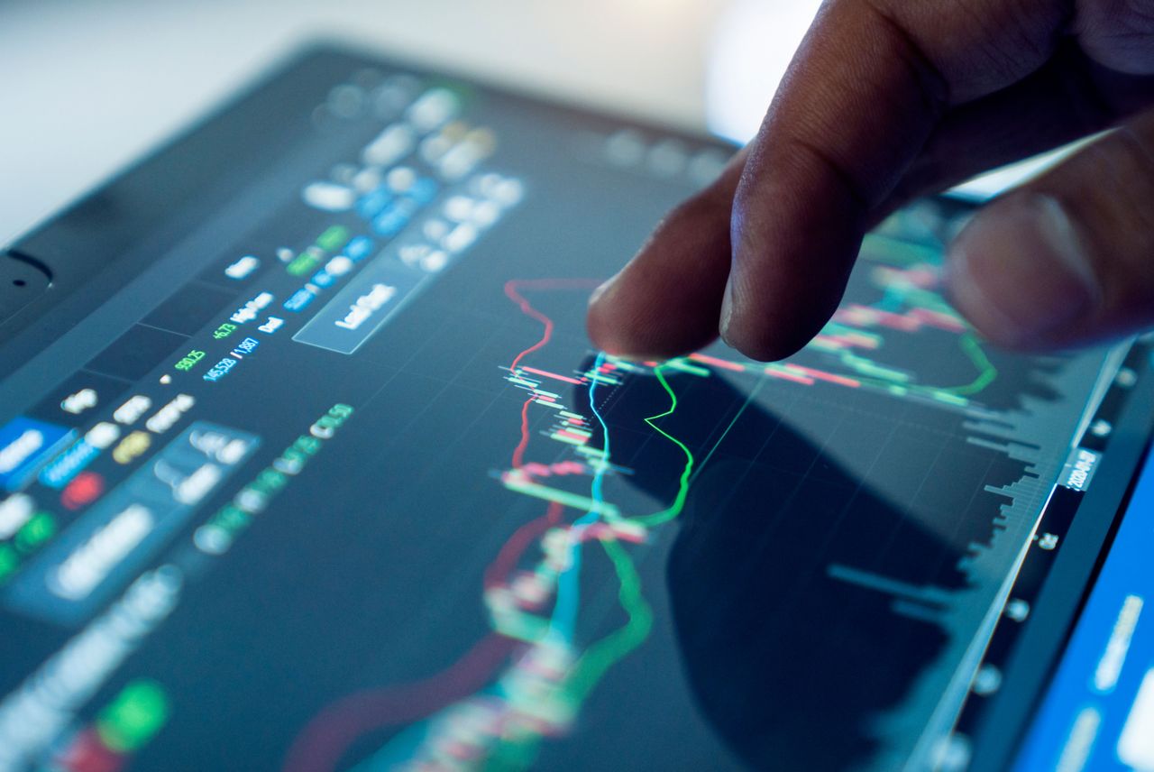 A person’s finger placed on a line on a stock chart. (Source: Getty Images)