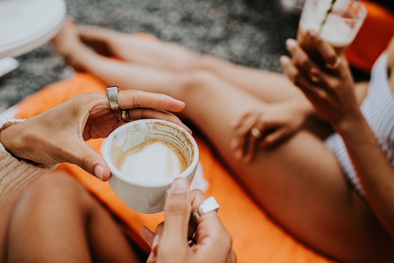 A woman drinks an espresso on the beach. Source: Getty Images