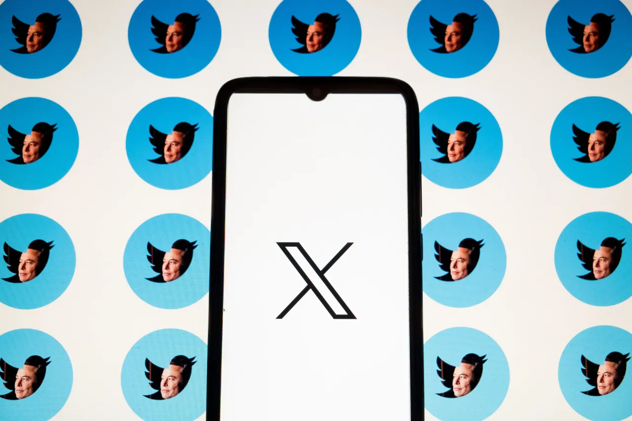 In this photo Illustration a X logo is seen on a smartphone screen and effigies of Elon Musk with the Twitter logos as background. (Photo Illustration by Nikolas Kokovlis/NurPhoto via Getty Images)
