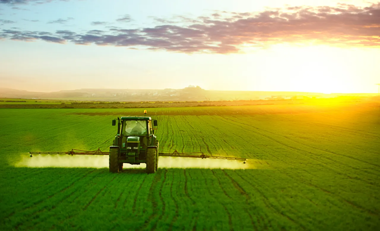 Tractor spraying a field of wheat. Bunge stock has gained 5% this year.