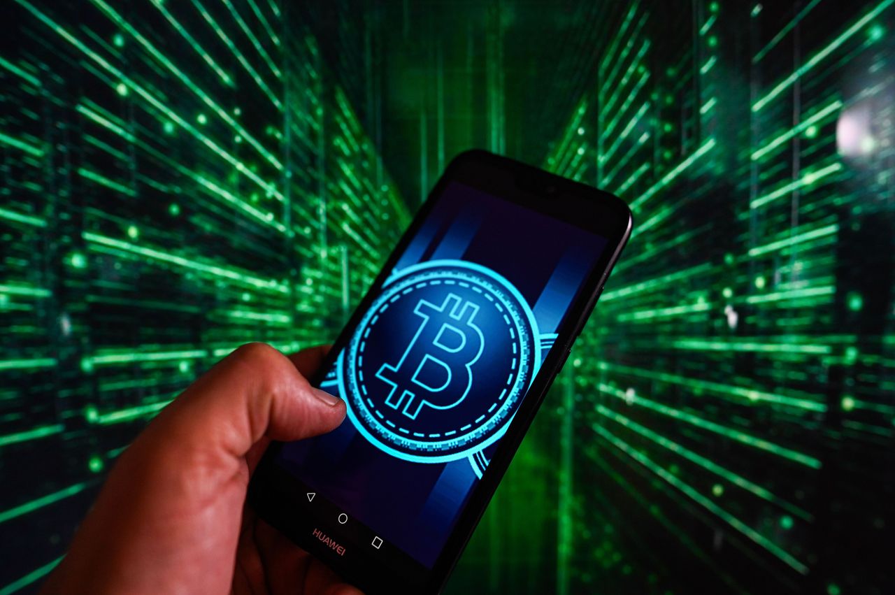 In this photo illustration, a Bitcoin logo displayed on a smartphone with stock server lights in the background. (Photo Illustration by Omar Marques/SOPA Images/LightRocket via Getty Images)