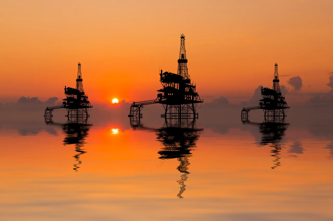 Sunset view with silhouette of an oil rig.