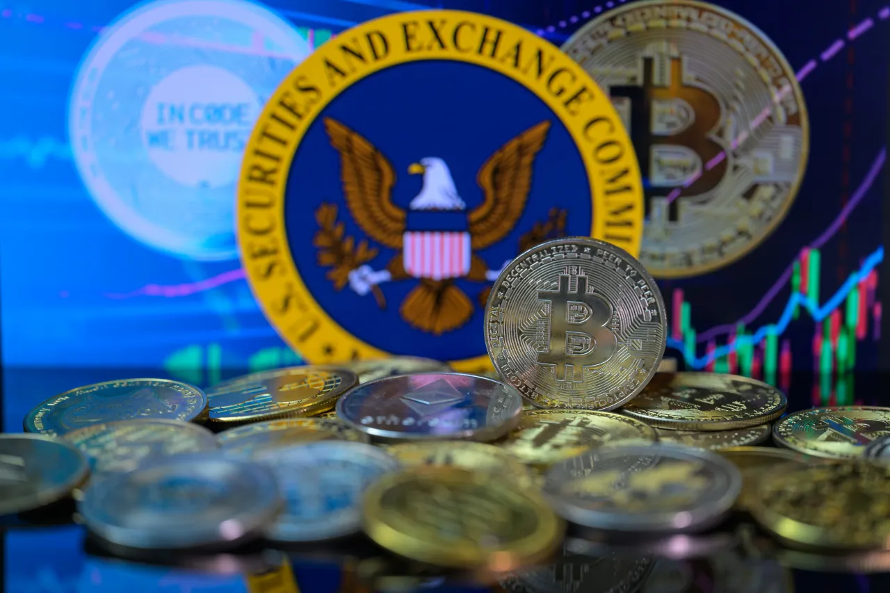 A visual representation of the digital cryptocurrency Bitcoin is displayed with the SEC seal in the background. (Photo by Jonathan Raa/NurPhoto via Getty Images)