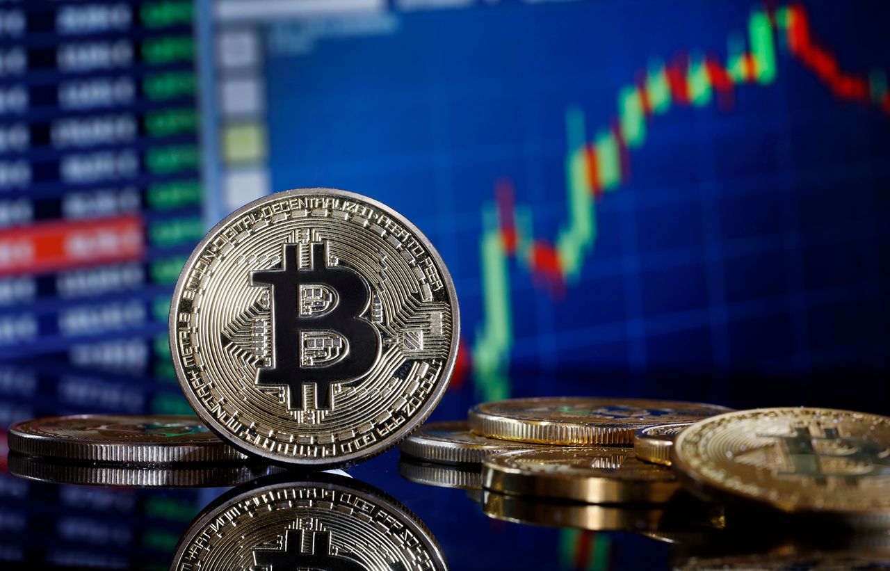 In this photo illustration, a visual representation of the digital cryptocurrency Bitcoin is displayed in front of a Bitcoin course's graph on January 11, 2024 in Paris, France. (Photo illustration by Chesnot/Getty Images)