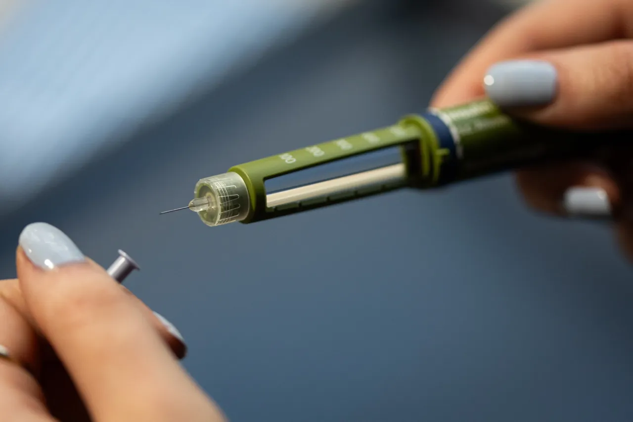A woman holds an insulin pen with an exposed injection needle. Photo: Hannes P. Albert/dpa (Photo by Hannes P Albert/picture alliance via Getty Images)