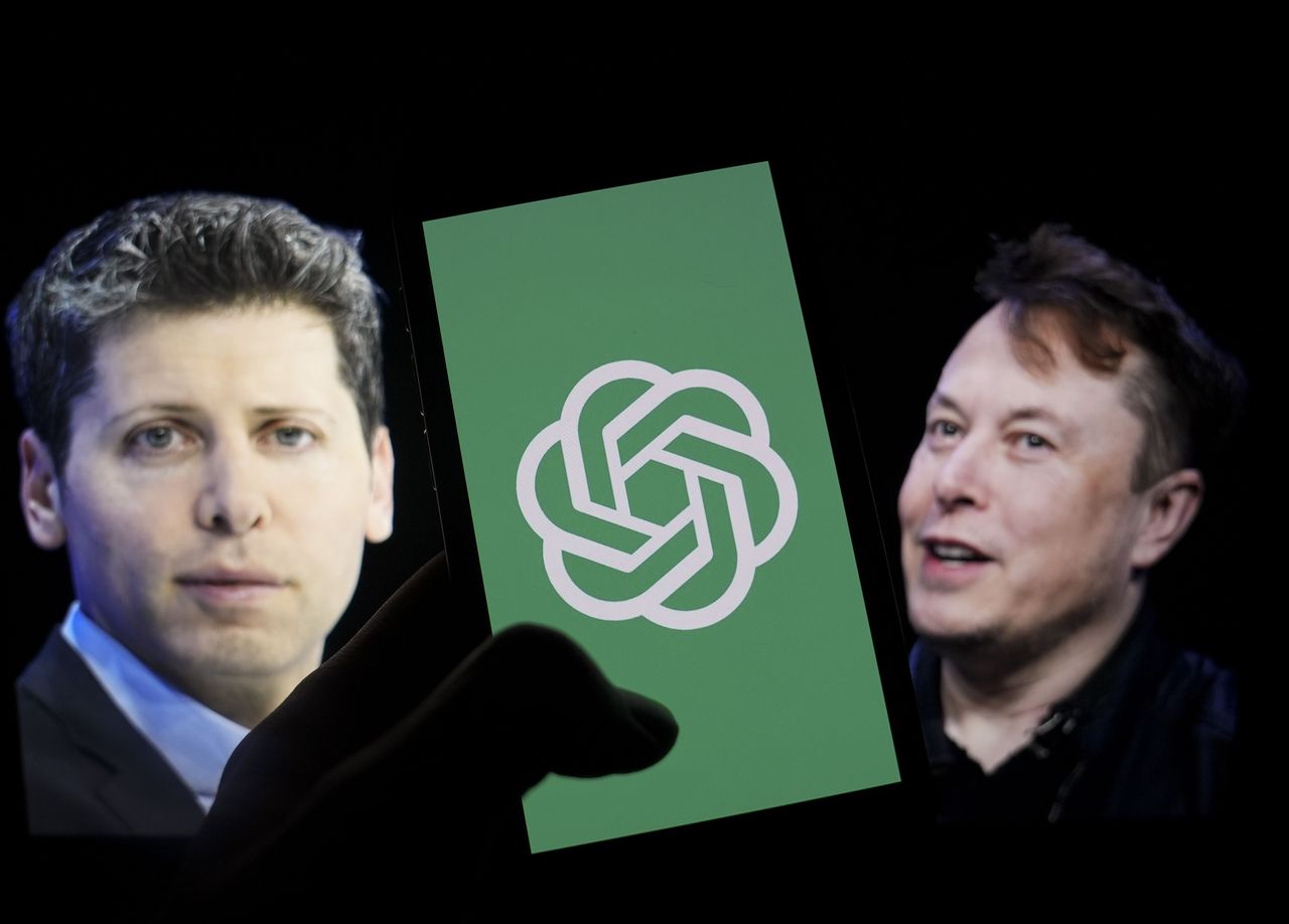 The logo of 'OpenAI' is displayed on a mobile phone screen in front of a computer screen displaying the photographs of Elon Musk and Sam Altman. (Photo by Muhammed Selim Korkutata/Anadolu via Getty Images)