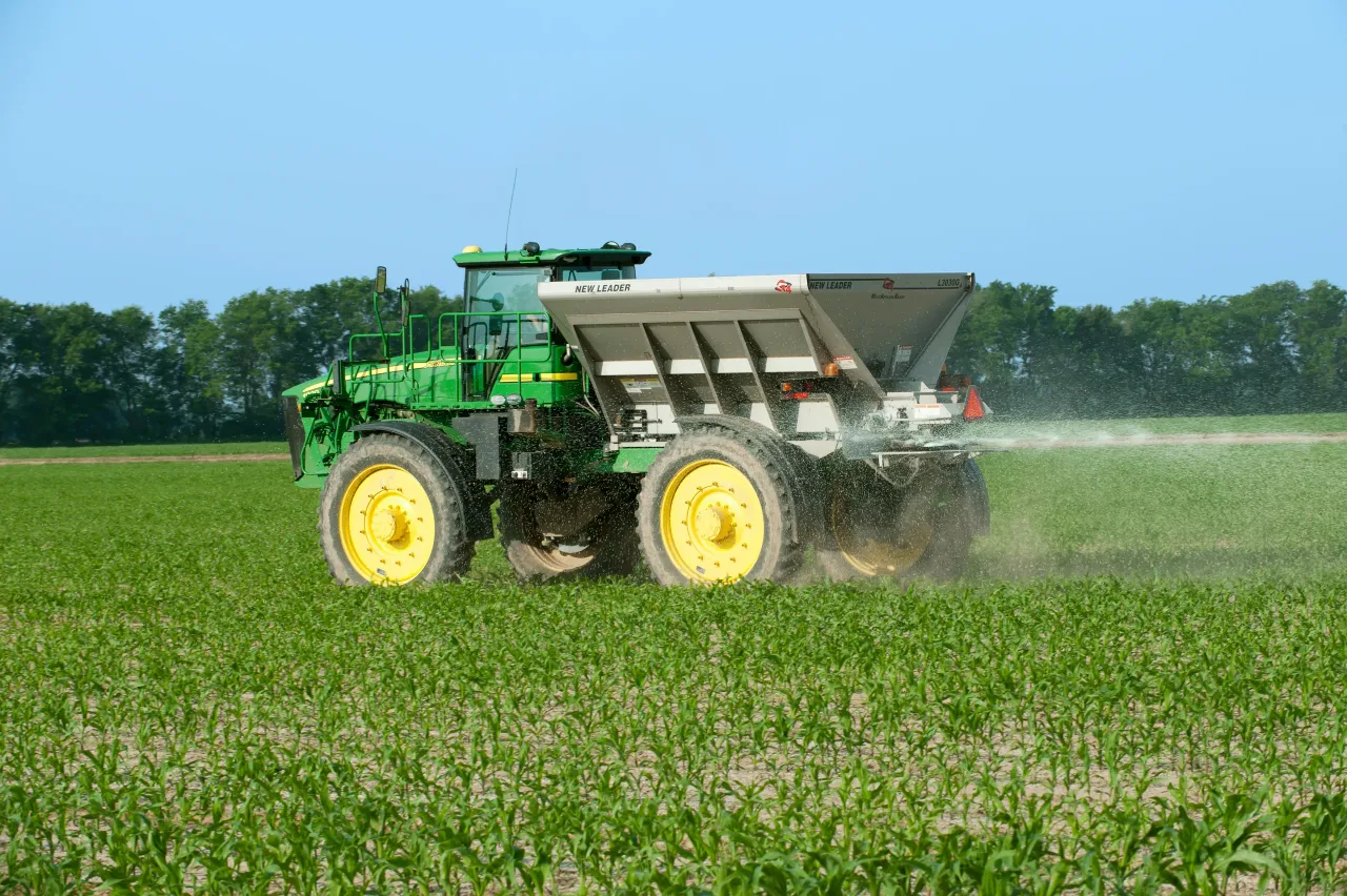 representational image of a tractor spraying fertilizers in the farm field