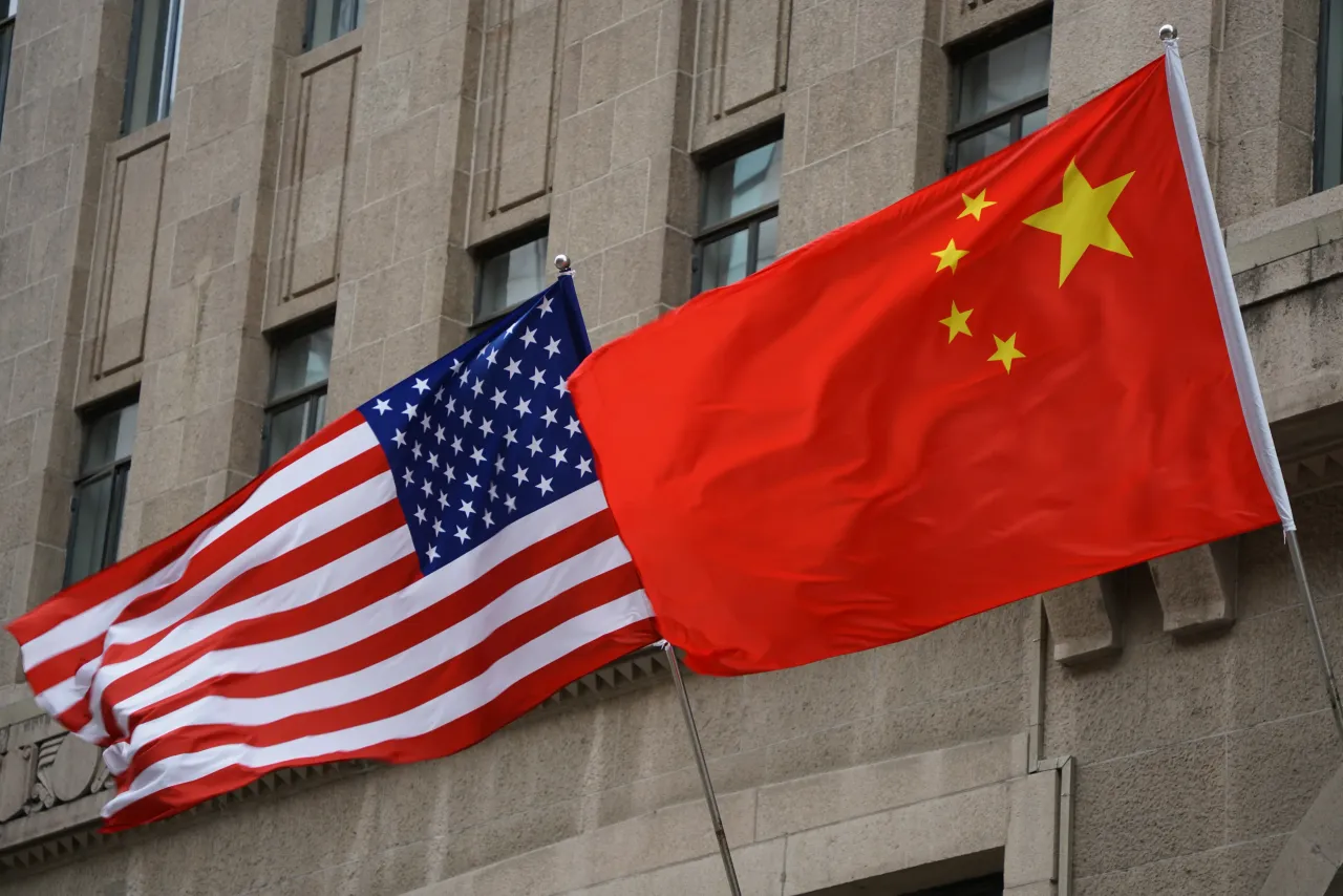 The national flags of the United States and China flutter at the Fairmont Peace Hotel.