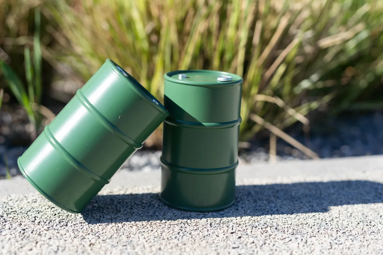 Close-up of green containers on footpath.