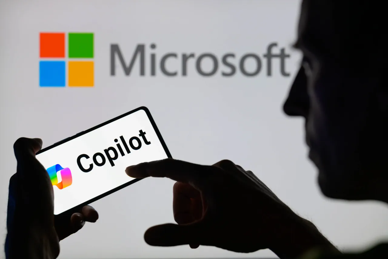 The Copilot logo is being displayed on a smartphone with Microsoft visible in the background. (Photo by Jonathan Raa/NurPhoto via Getty Images)