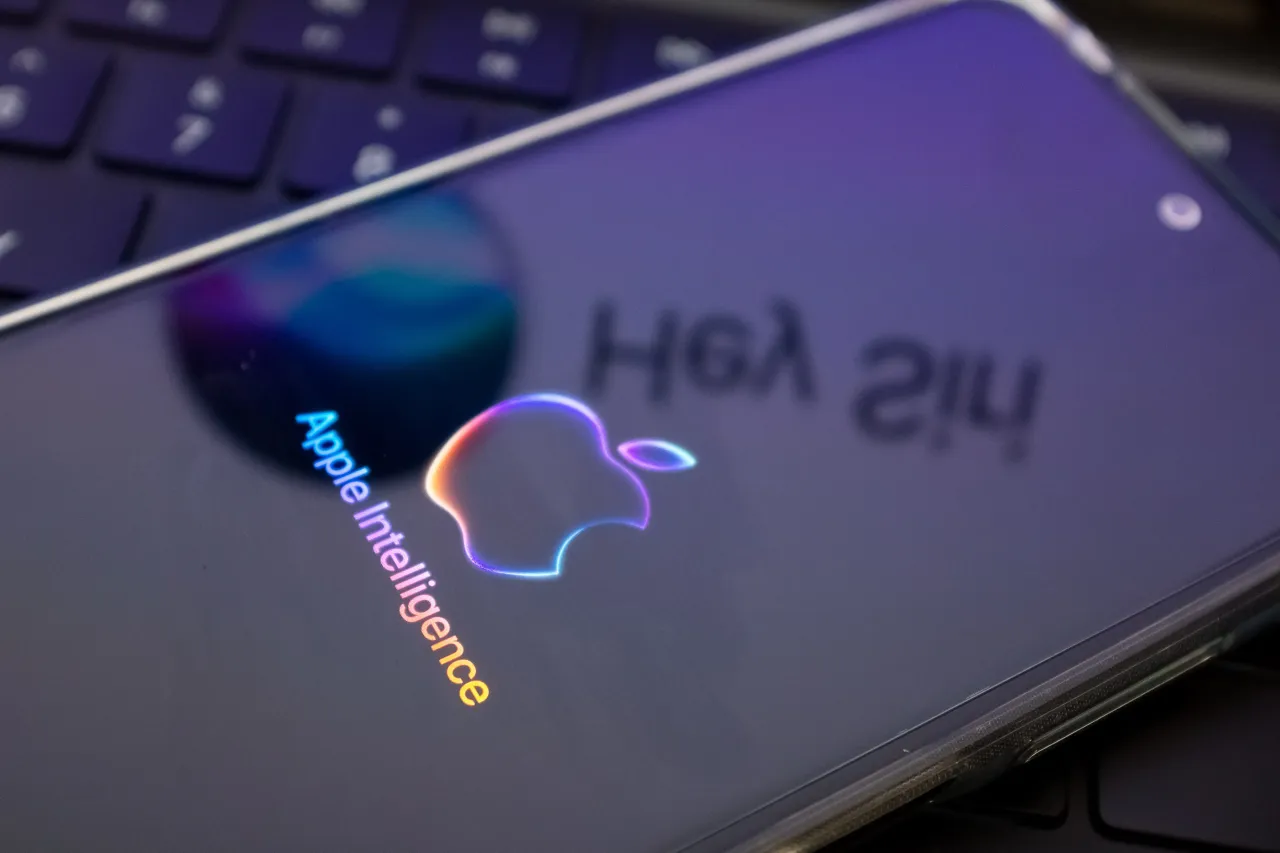 The Apple Intelligence logo is being displayed on a smartphone, with the Apple Siri logo in the background. (Photo by Nikolas Kokovlis/NurPhoto via Getty Images)