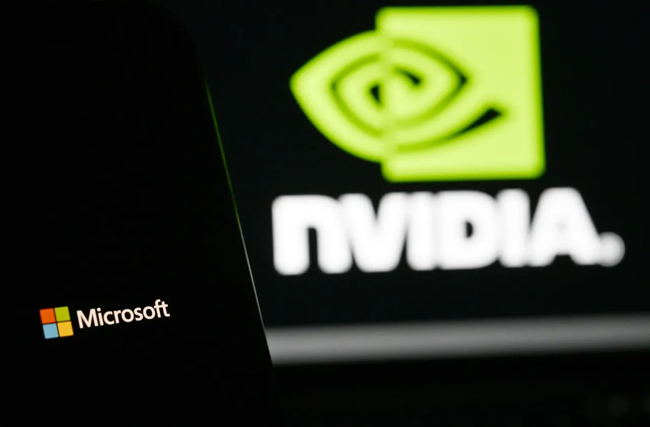 In this photo illustration, the 'Microsoft' logo is displayed on a mobile phone screen in front of a computer screen displaying Nvidia logo.