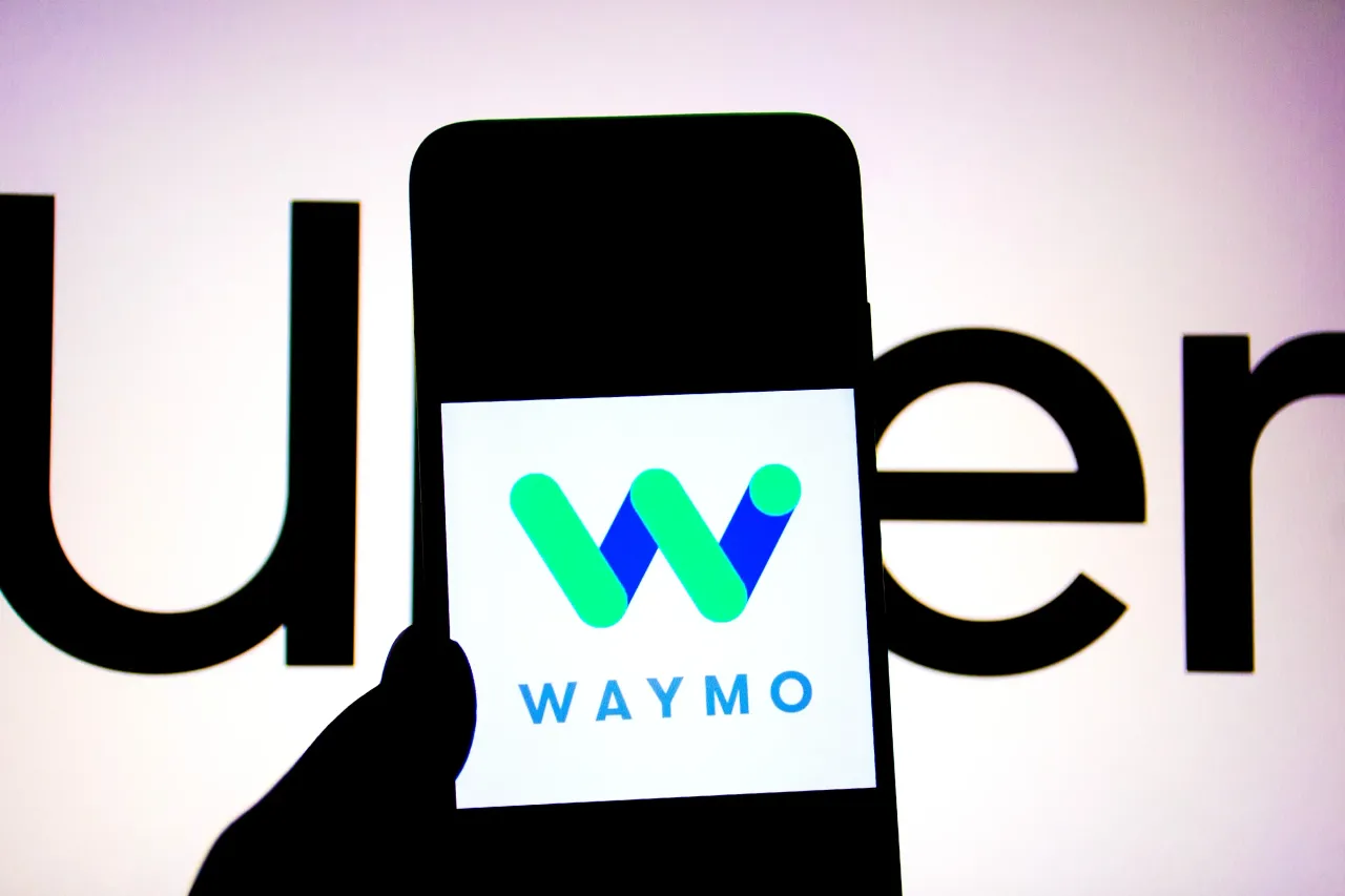 In this photo illustration, a Waymo logo seen displayed on a smartphone with an UBER Logo in the background. (Photo Illustration by Avishek Das/SOPA Images/LightRocket via Getty Images)
