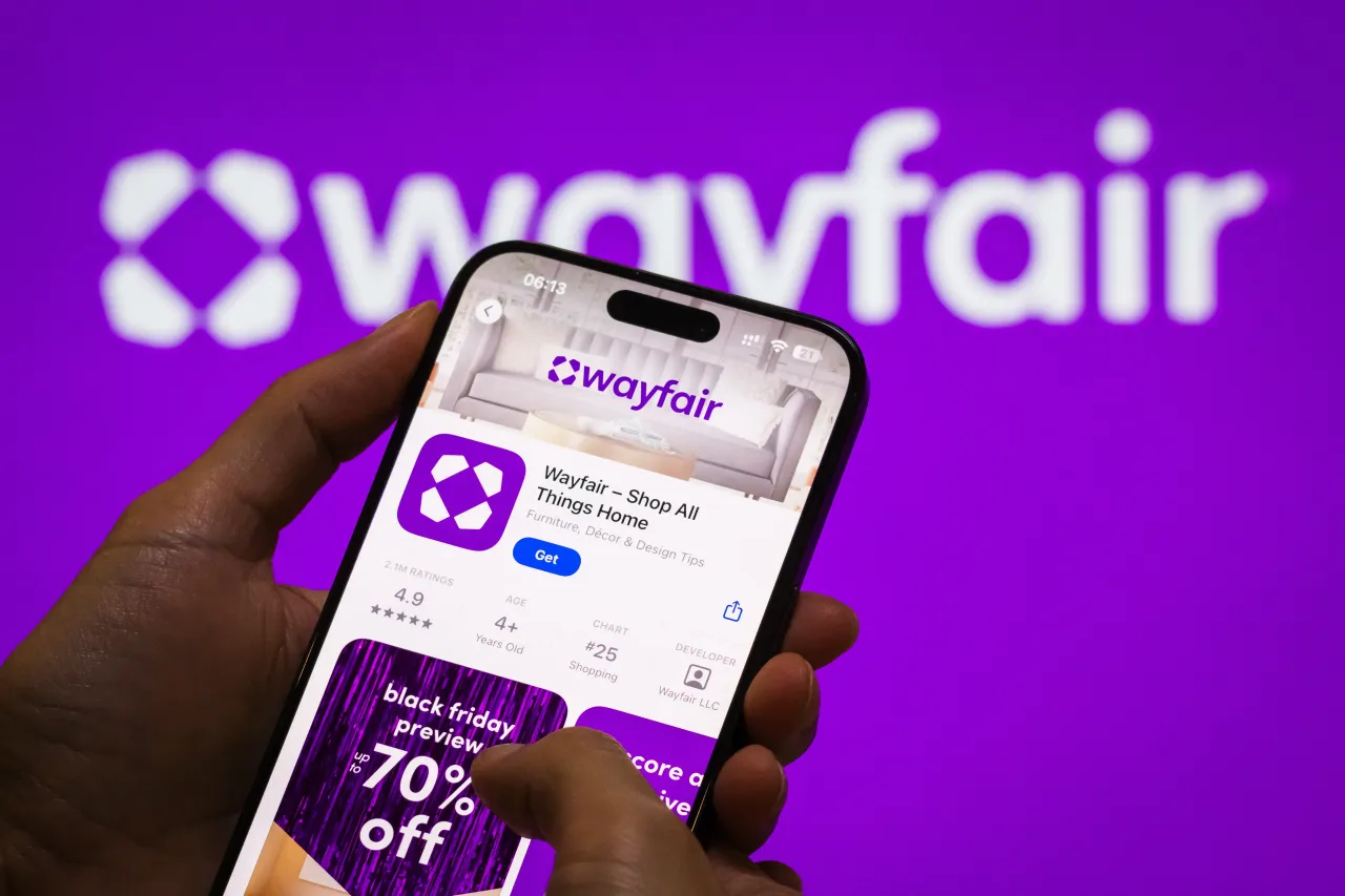 The Wayfair app page is displayed on a smartphone in the Apple App Store in front of the Wayfair Inc. logo. (Photo by Cheng Xin/Getty Images)