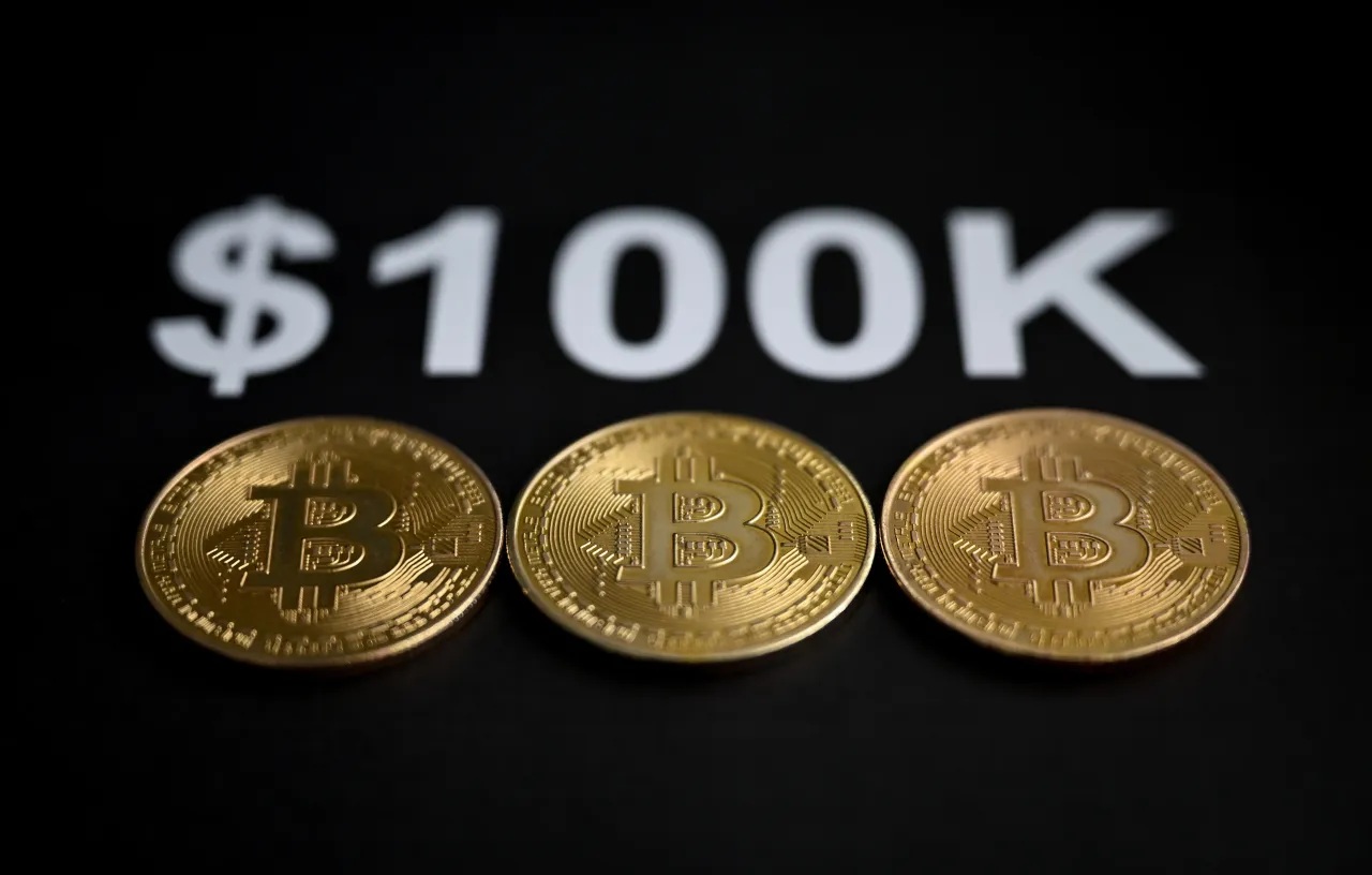 In this photo illustration, 'Bitcoin' coins are displayed with the bold text '$100K' above them in Ankara, Turkiye on November 23, 2024. (Photo by Hakan Nural/Anadolu via Getty Images)