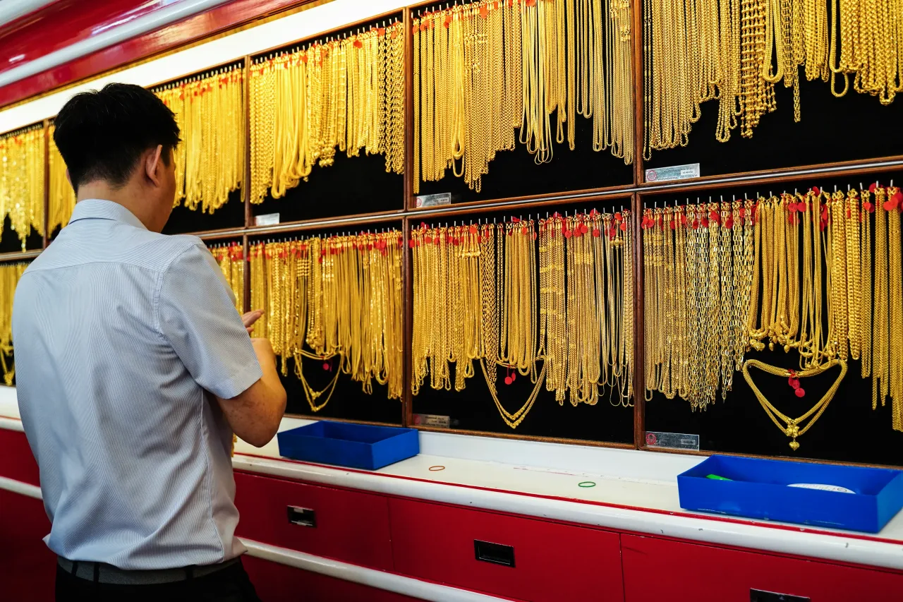 A gold seller selects golden ornaments for sale at the gold shop ahead of the Chinese Lunar New Year in Chinatown, Bangkok, Thailand, on January 25, 2025. (Photo by Anusak Laowilas/NurPhoto via Getty Images)