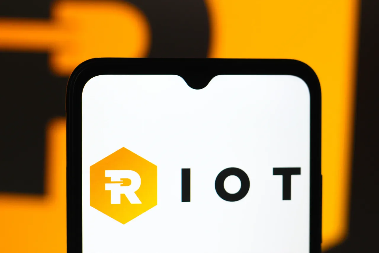 In this photo illustration, the Riot Platforms, Inc. logo is displayed on a smartphone screen. (Photo Illustration by Thomas Fuller/SOPA Images/LightRocket via Getty Images)