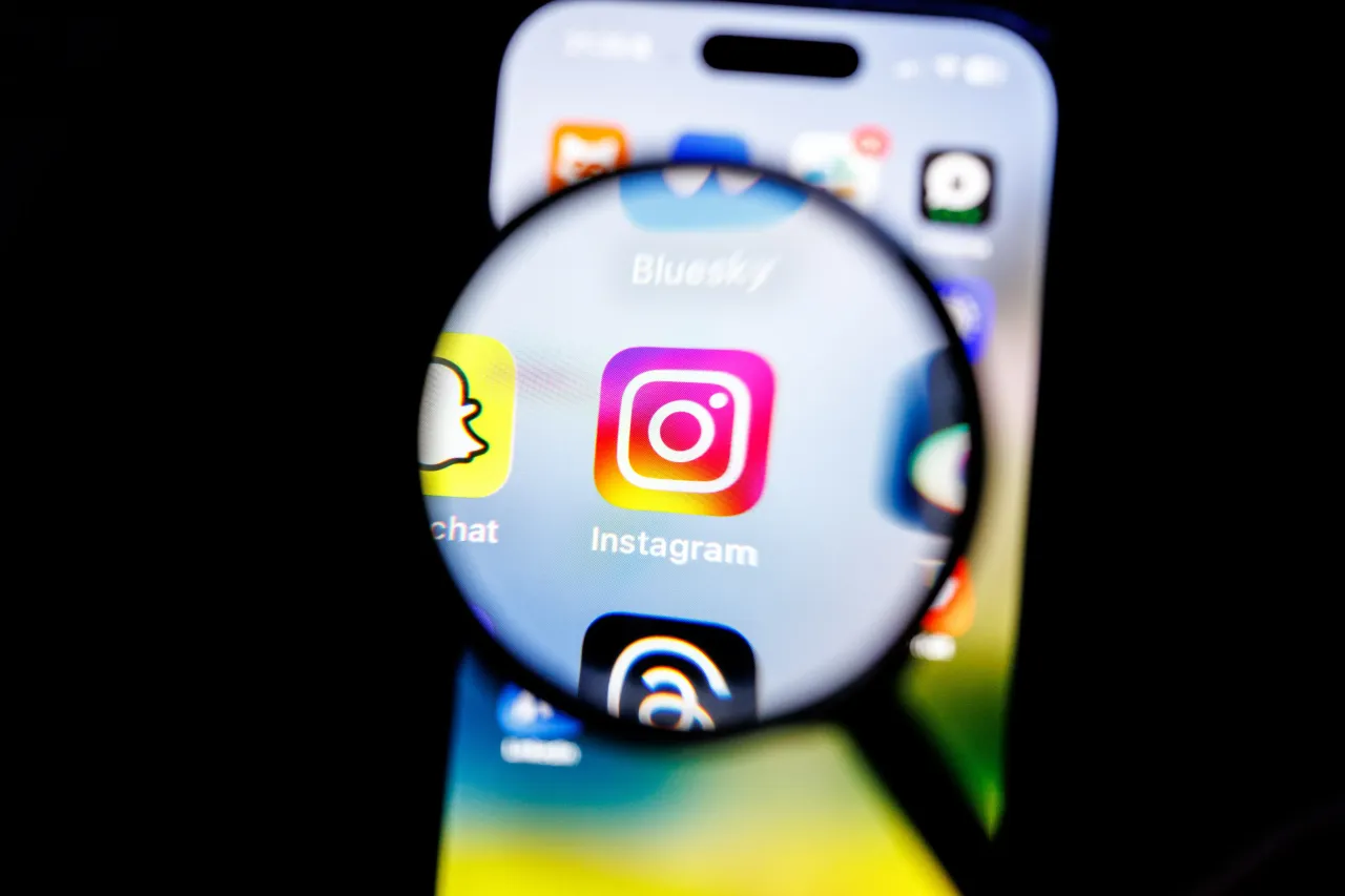 The logo of the Instagram app can be seen through a magnifying glass on the display of a smartphone on February 19, 2025. (Photo by Matthias Balk/picture alliance via Getty Images)
