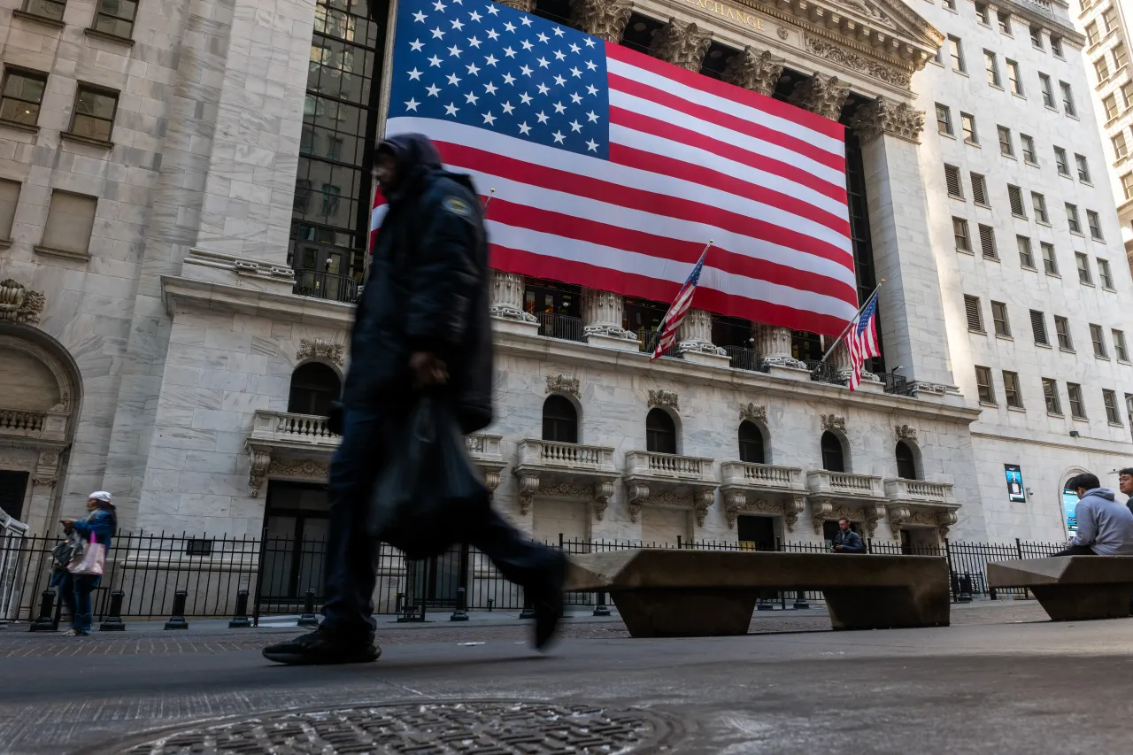 People walk by the New York Stock Exchange (NYSE).