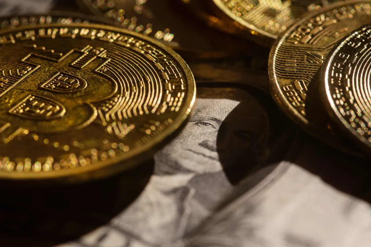 Golden Bitcoin coins lie on a US dollar banknote. Photo: Fernando Gutierrez-Juarez/dpa (Photo by Fernando Gutierrez-Juarez/picture alliance via Getty Images)