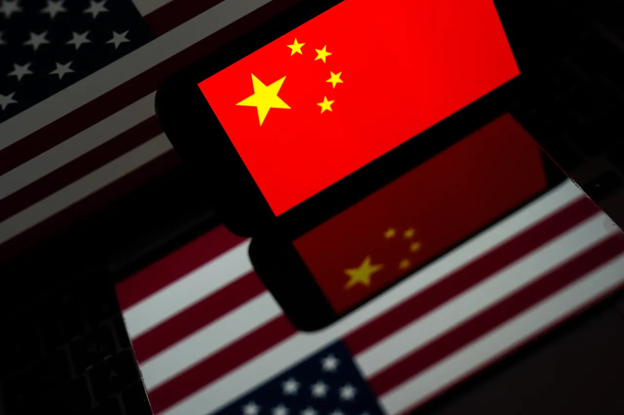 In this photo illustration US flag is displayed on computer screen while Chinese flag is displayed on mobile phone screen. (Photo by Dilara Irem Sancar/Anadolu via Getty Images)