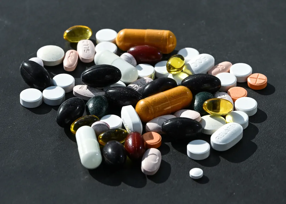 A photo illustration showing a mix of various tablets and pharmaceutical products, primarily manufactured by U.S. pharmaceutical companies. (Photo by Artur Widak/NurPhoto via Getty Images)