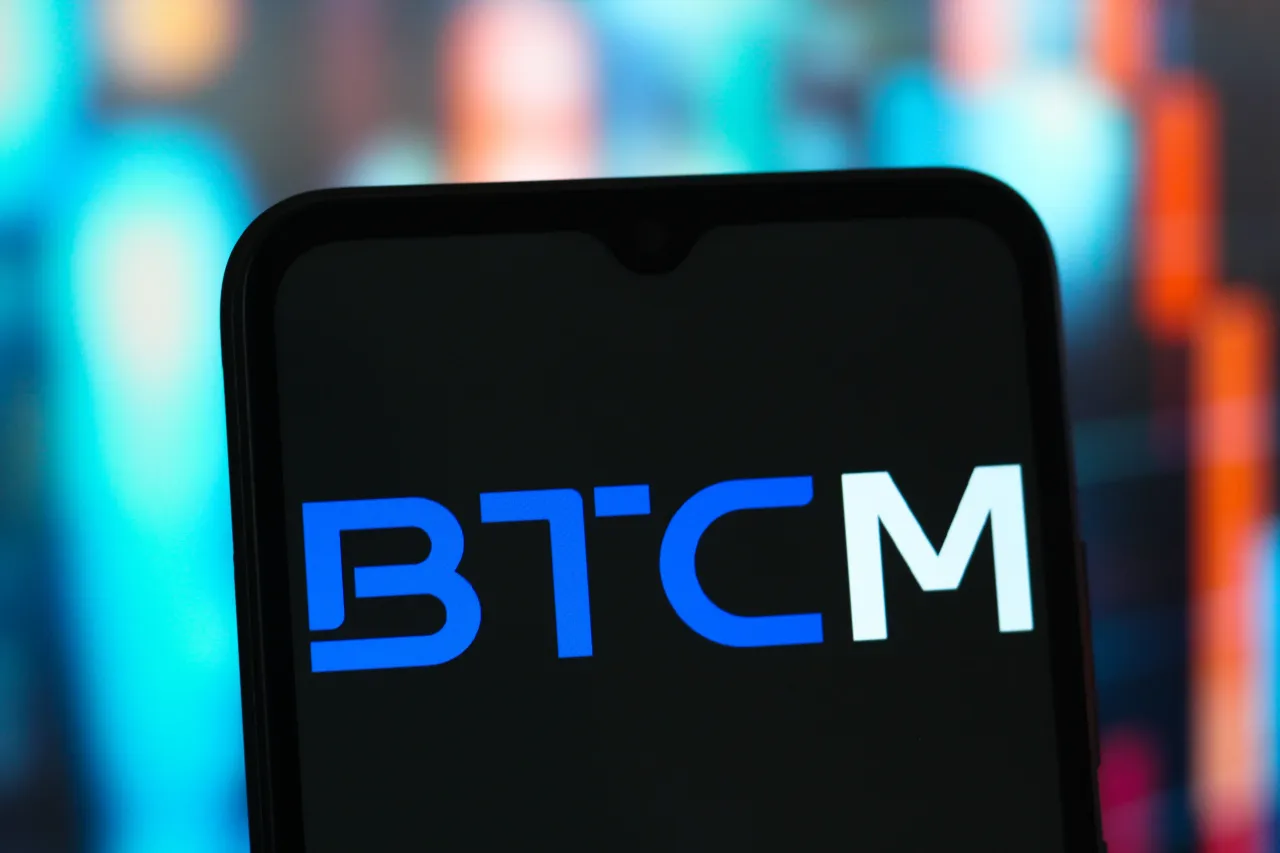 In this photo illustration, the BTCM Group (BIT Mining Limited) logo is seen displayed on a smartphone screen. 