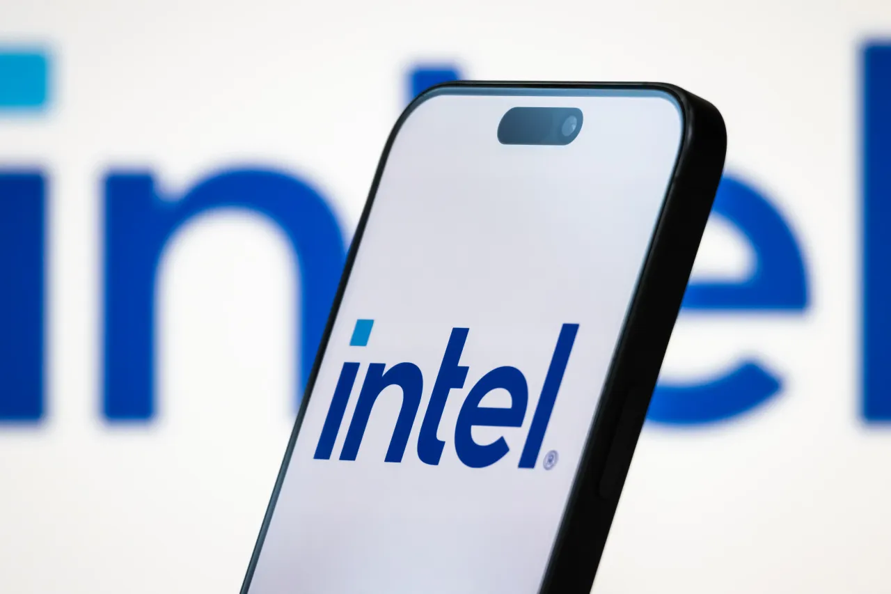 Intel logo is on a smartphone screen, with the company's branding in the background. Donald Trump posted AI-generated picture showing him trading Intel stock. (Photo by Cheng Xin/Getty Images)