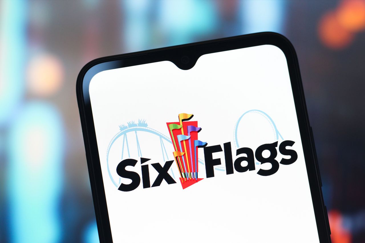 In this photo illustration, the Six Flags Entertainment logo is seen displayed on a smartphone screen.