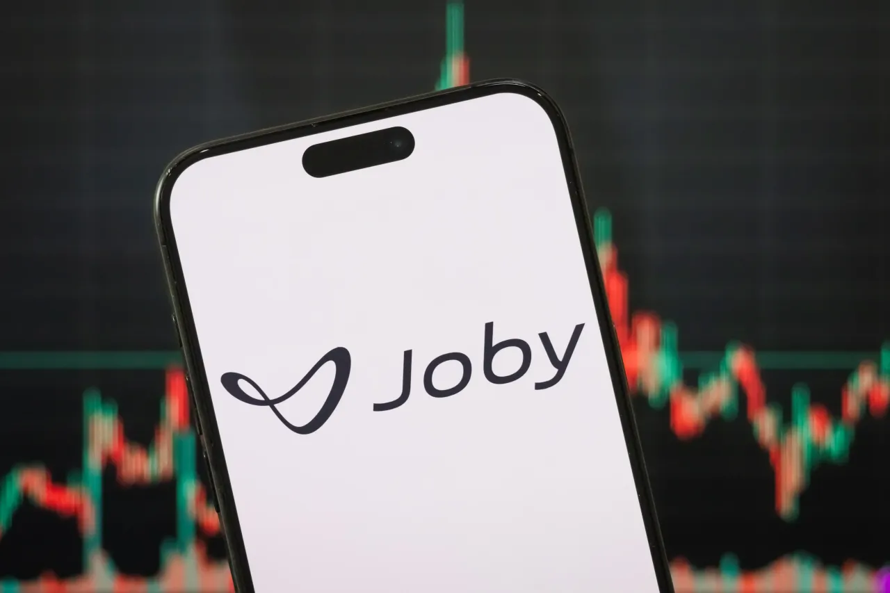 In this photo illustration, the logo of Joby Aviation, Inc. is displayed on a smartphone screen with a stock market chart in the background, on May 04, 2025, in Chongqing, China. (Photo illustration by Cheng Xin/Getty Images)