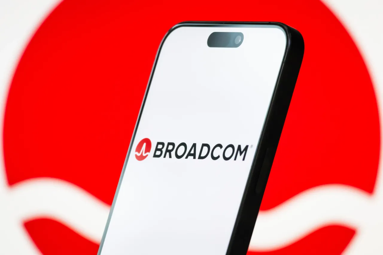 Broadcom Inc. logo displayed on a smartphone screen, with the company's signature red wave branding visible in the background. (Photo illustration by Cheng Xin/Getty Images)