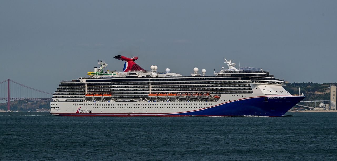Carnival Miracle, a 88,500 GT Spirit-class cruise ship operated by Carnival Cruise Line, sails the Tagus River.