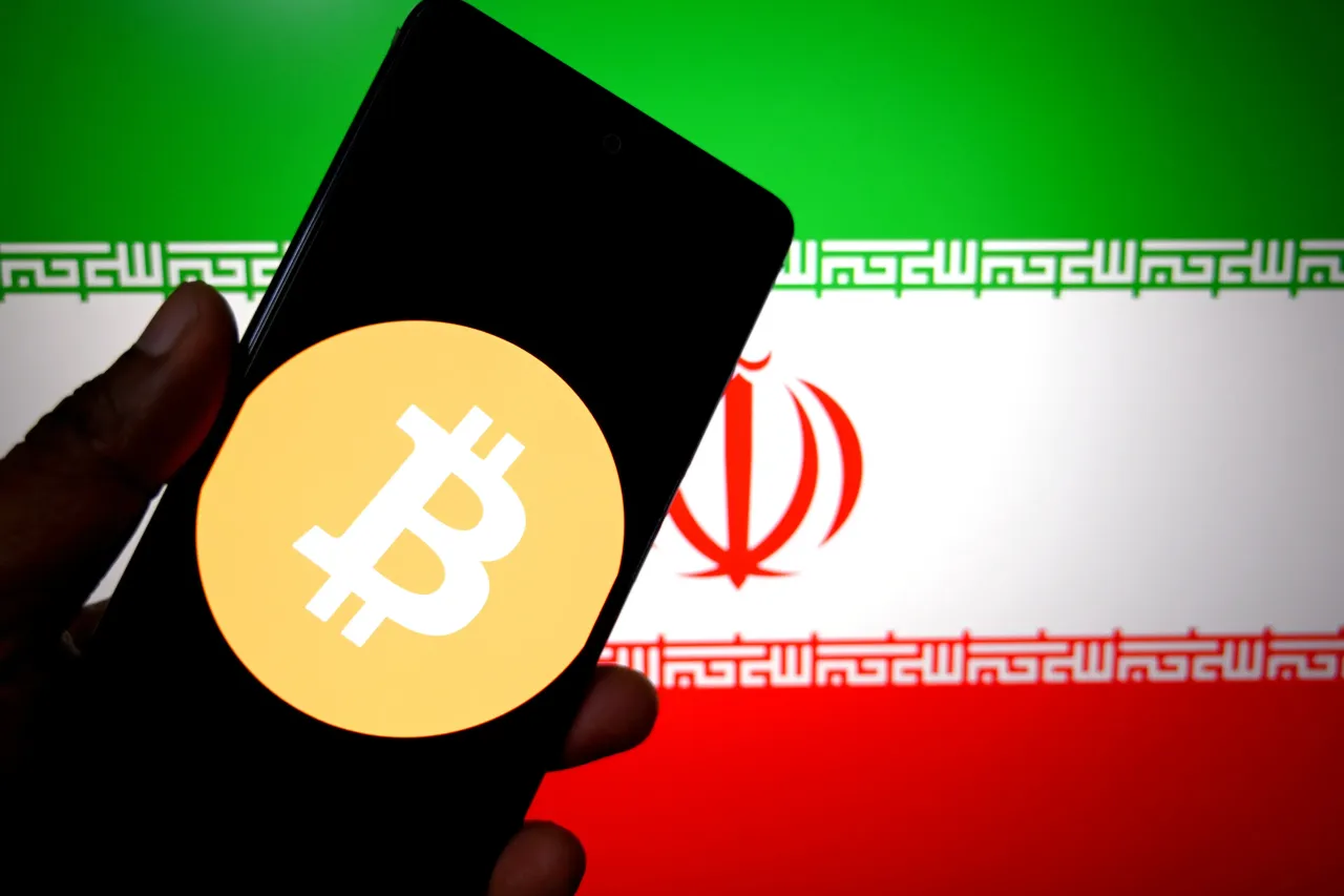 In this photo illustration, a Bitcoin logo is seen displayed on a smartphone with the flag of Iran in the background. (Photo Illustration by Avishek Das/SOPA Images/LightRocket via Getty Images)
