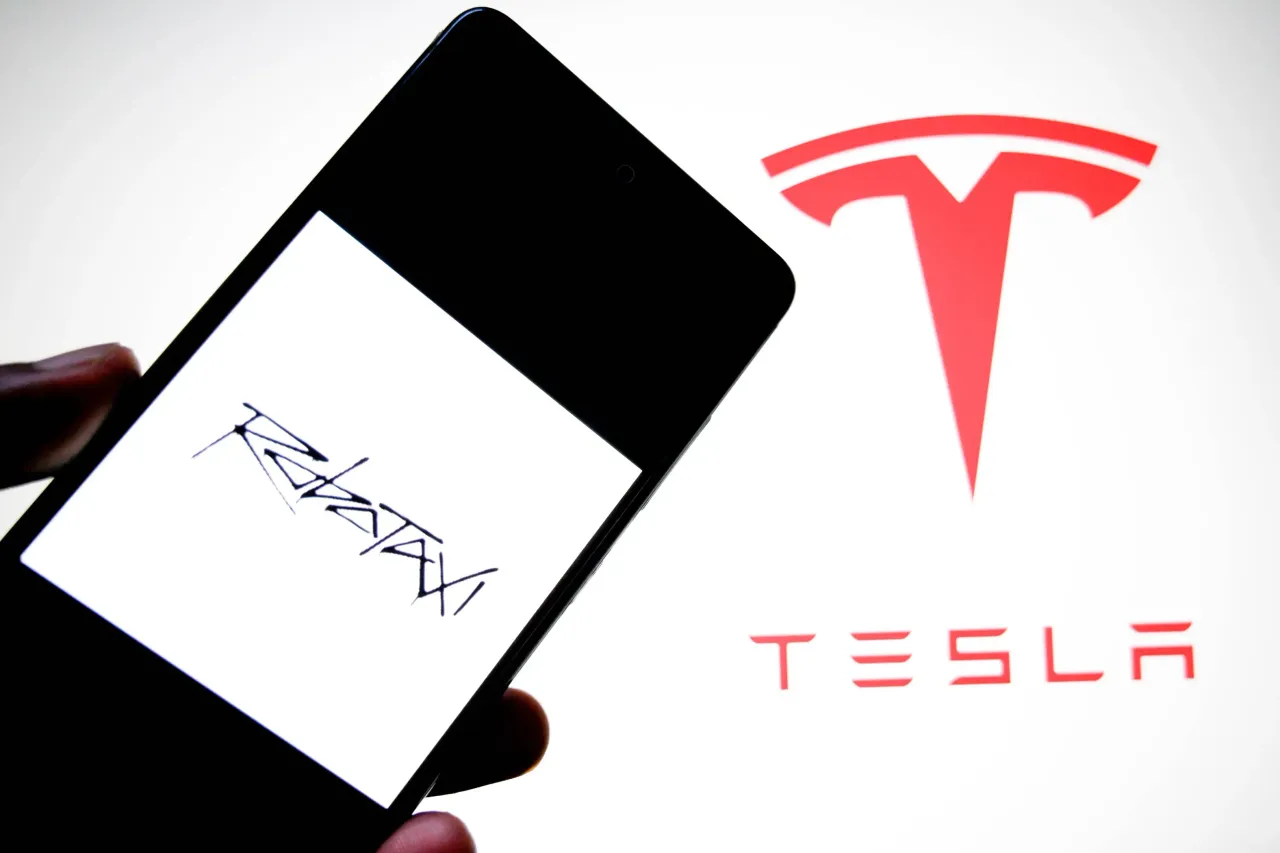 In this photo illustration, a Robotaxi logo is seen displayed on a smartphone with a Tesla logo in the background. (Photo Illustration by Avishek Das/SOPA Images/LightRocket via Getty Images)