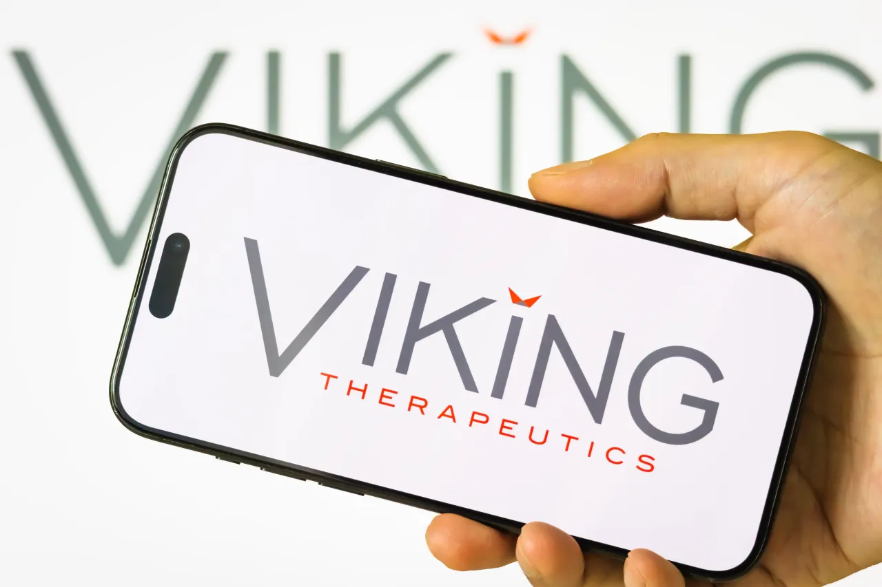 In this photo illustration, a person holds a smartphone displaying the logo of Viking Therapeutics on July 19, 2025. (Photo illustration by Cheng Xin/Getty Images)
