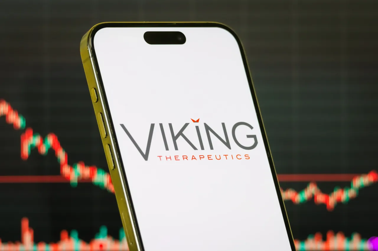 In this photo illustration, a smartphone displays the logo of Viking Therapeutics, Inc., in front of a screen showing the company's latest stock market chart on July 19, 2025 in Chongqing, China. (Photo illustration by Cheng Xin/Getty Images)