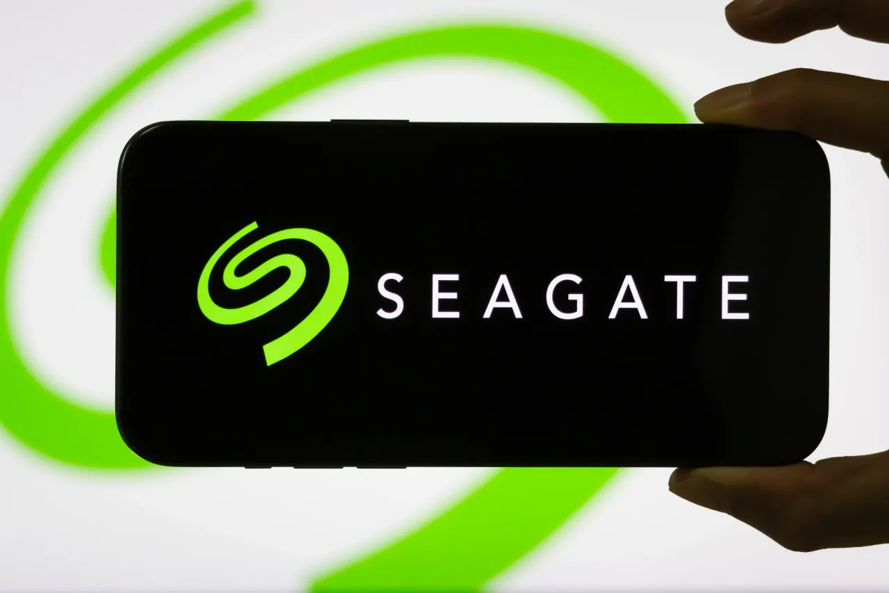 In this photo illustration, a person holds a smartphone displaying the logo of Seagate Technology Holdings PLC.