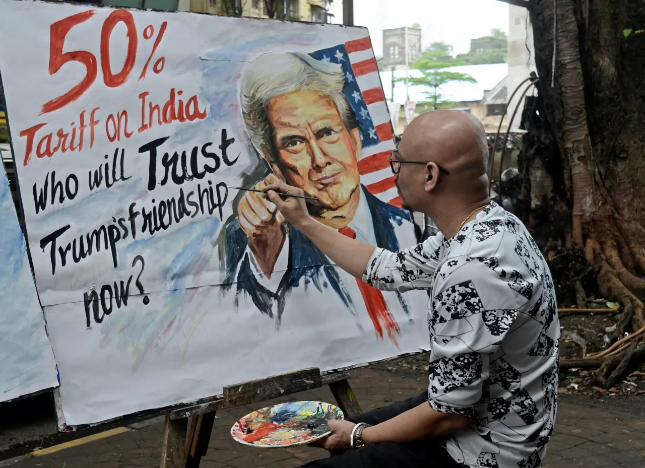 An artist paints a protest artwork depicting Donald Trump, following reports of a proposed 50% tariff on Indian imports by the United States. (Photo by Indranil Aditya/NurPhoto via Getty Images)