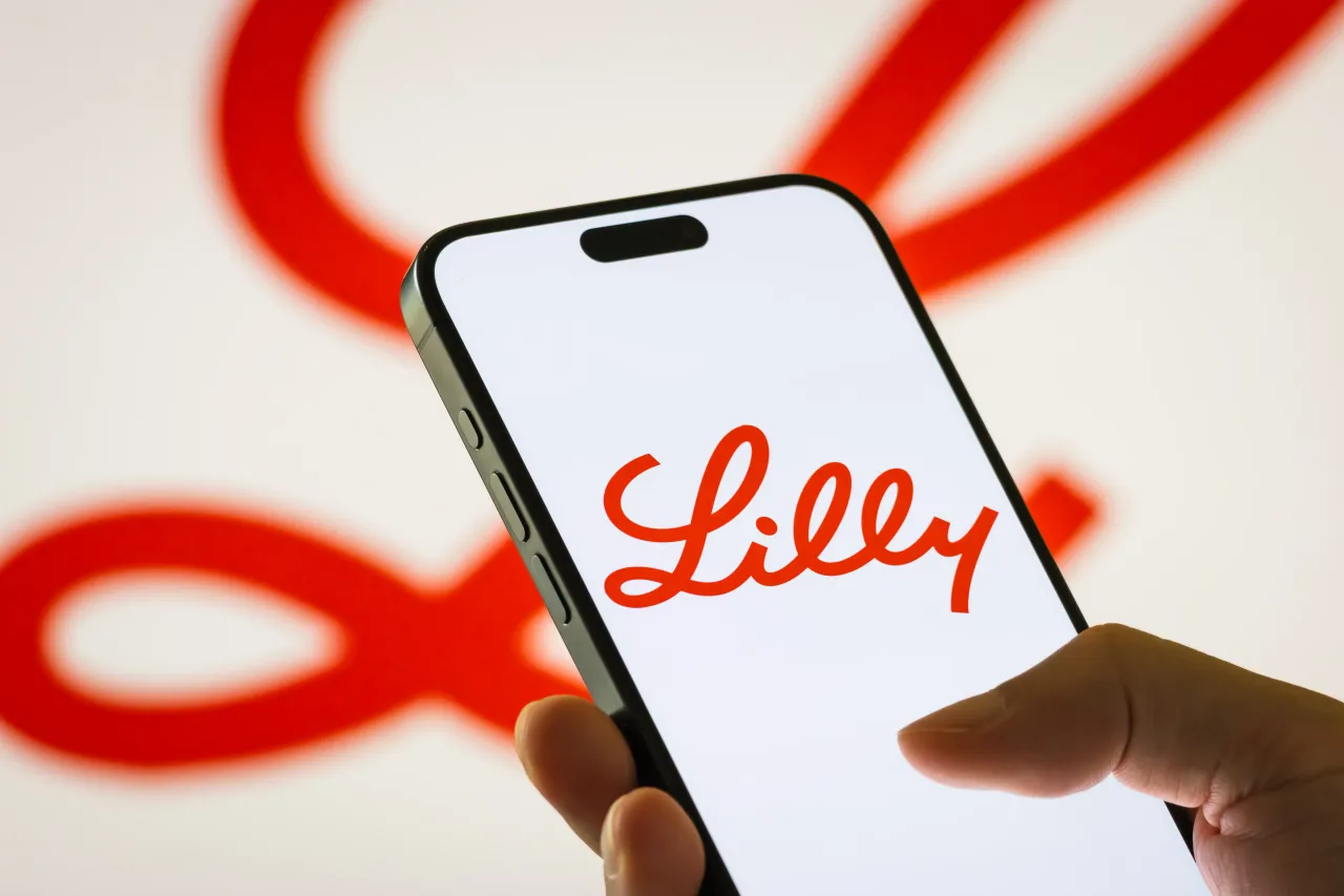 In this photo illustration, a person holds a smartphone displaying the logo of Eli Lilly and Company on August 7, 2025 in Chongqing, China. (Photo illustration by Cheng Xin/Getty Images)
