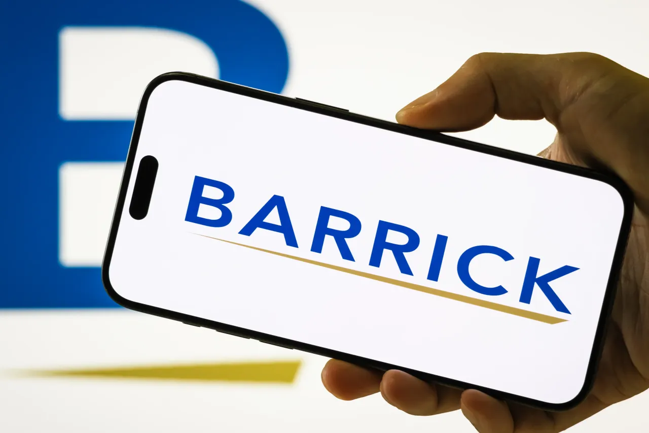 In this photo illustration, a person holds a smartphone displaying the logo of Barrick Mining Corporation. 