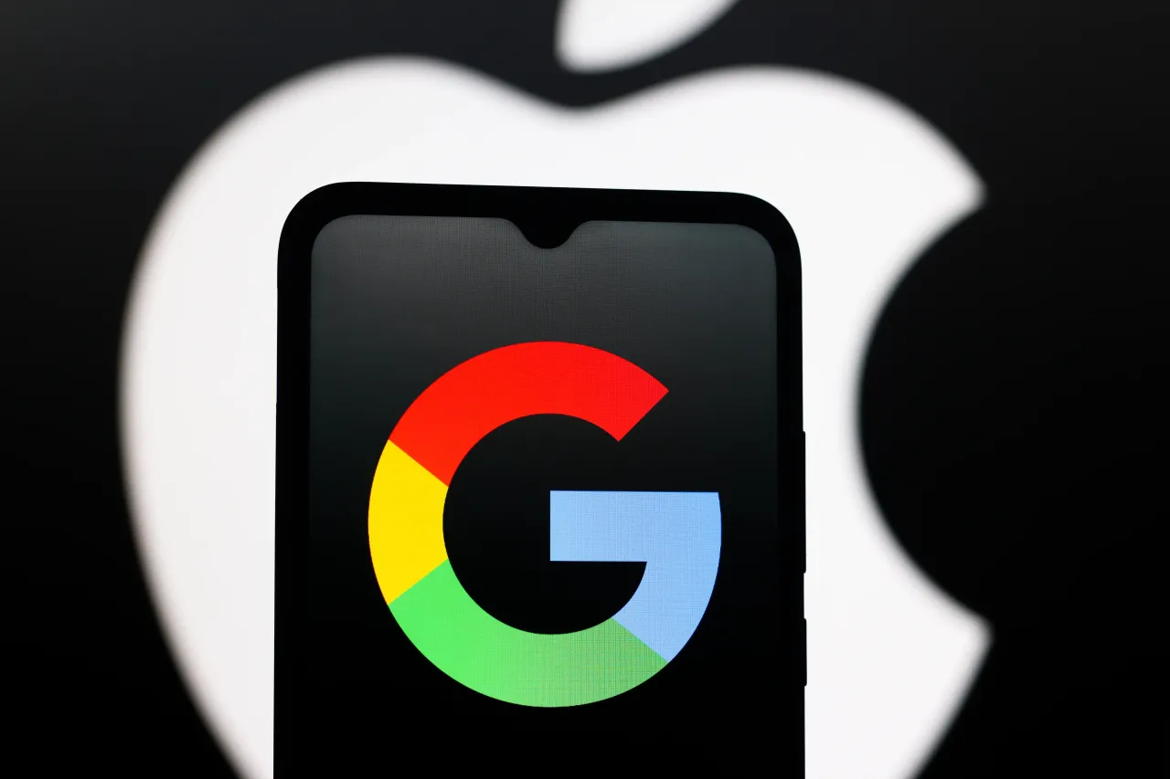 In this photo illustration, the Google logo is seen displayed on a smartphone screen and the Apple logo in the background. (Photo Illustration by Thomas Fuller/SOPA Images/LightRocket via Getty Images)