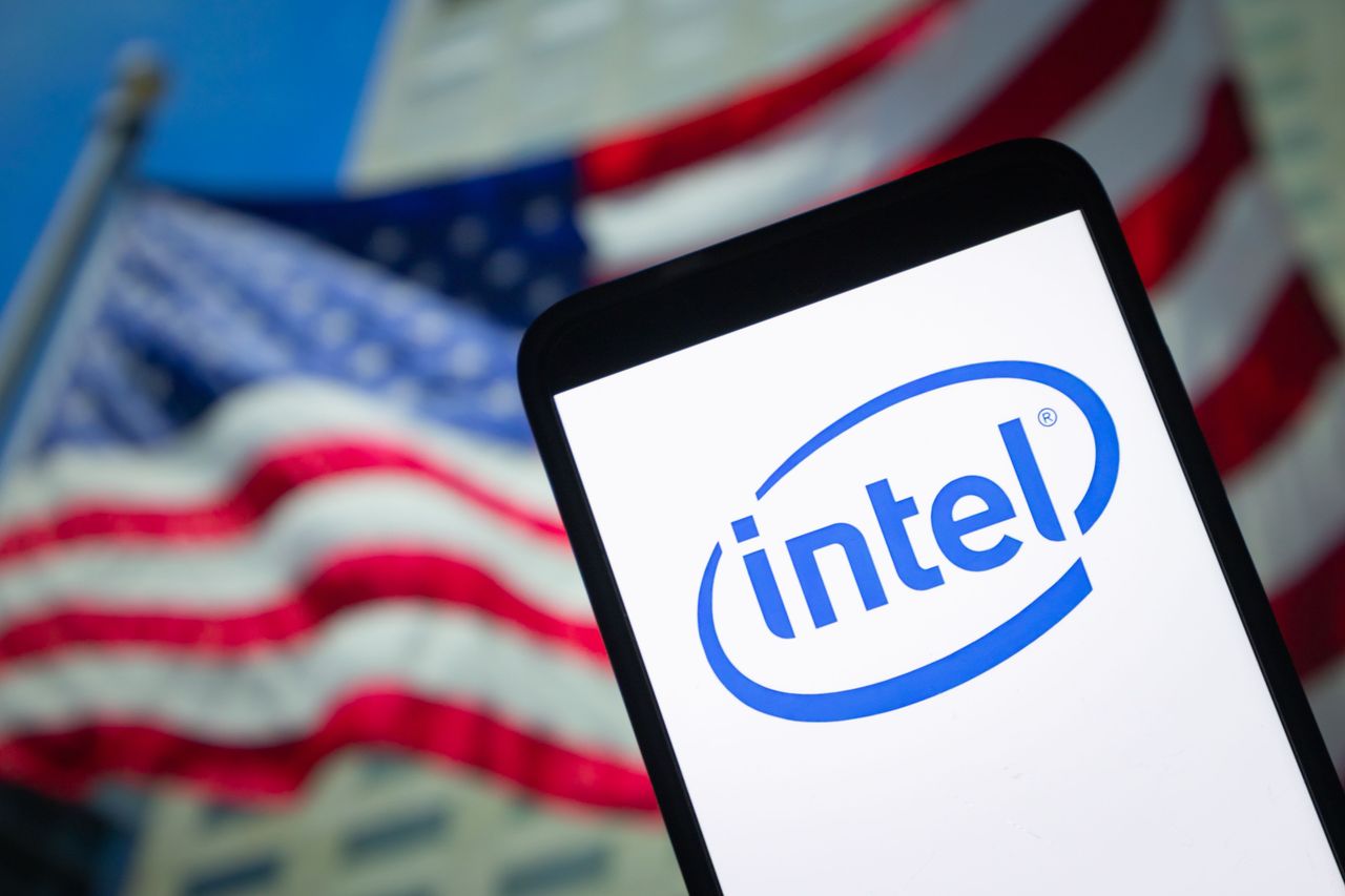The logo of Intel is displayed on a smartphone screen with a US national flag in the background. (Photo by Li Hongbo/VCG via Getty Images)