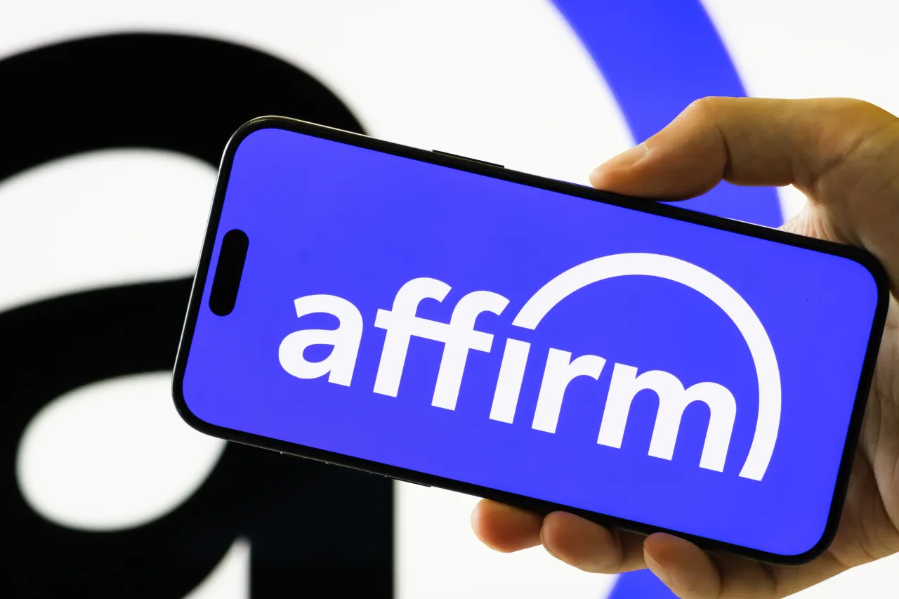  In this photo illustration, a person holds a smartphone displaying the logo of Affirm Holdings, Inc. 