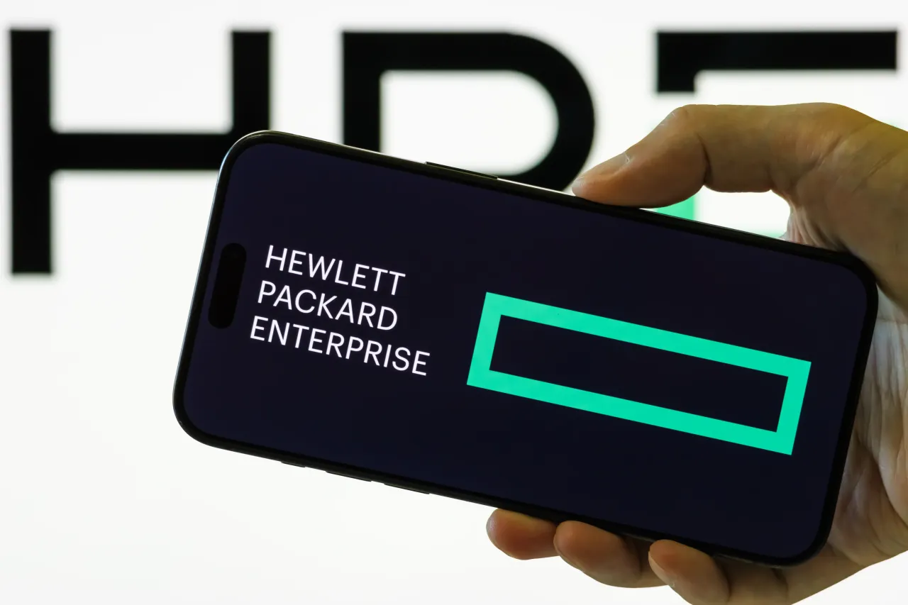 A person holds a smartphone displaying the logo of Hewlett Packard Enterprise Co. (Photo illustration by Cheng Xin/Getty Images)