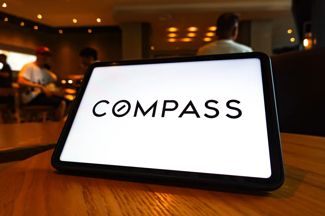 In this photo illustration, the Compass logo is displayed on the screen of a tablet. (Photo Illustration by Sheldon Cooper/SOPA Images/LightRocket via Getty Images)