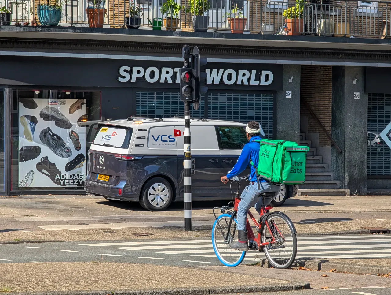 An Uber Eats courier rides a bicycle through the streets of Amsterdam, Netherlands, on September 10, 2025. The rider carries a large green delivery bag. (Photo by Michael Nguyen/NurPhoto via Getty Images)