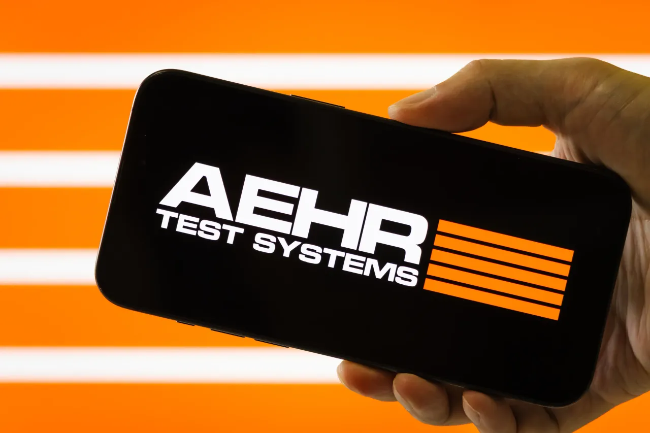 In this photo illustration, a hand holds a smartphone displaying the logo of Aehr Test Systems.