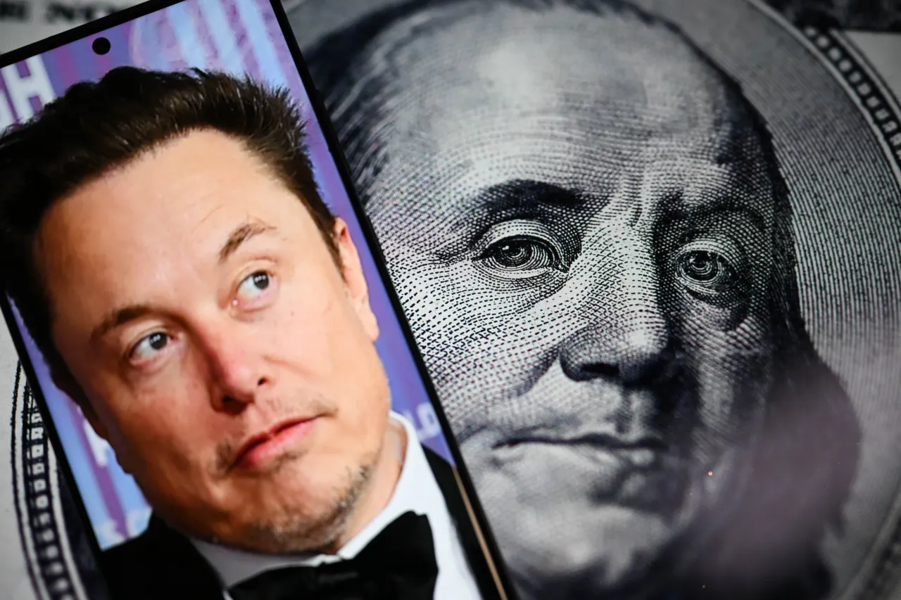 In this photo illustration, a portrait of the businessman Elon Musk is displayed on a mobile phone screen in front of a computer screen beside a dollars bill. 